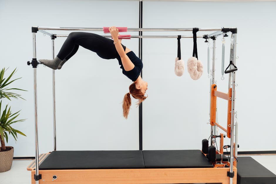 A woman engaging in a Pilates routine on a Reformer machine, showcasing strength and flexibility.